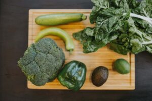 Food swaps for improved health and well-being. This image shows a cutting board full of green vegetables.