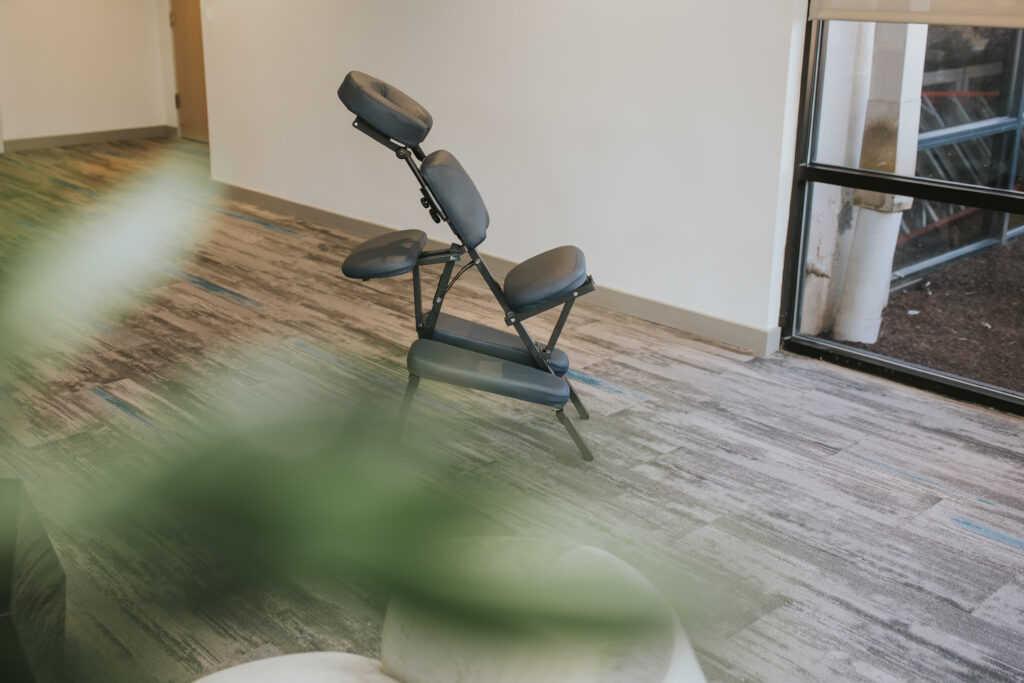 Portable chair massage setup in a small office corner showing how little space is needed for this employee wellness solution.