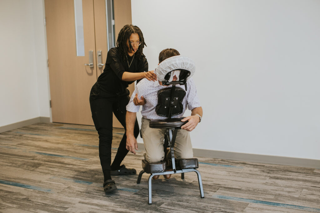 Chair massage session in the workplace demonstrating an easy employee wellness solution for reducing stress and improving employee wellbeing.