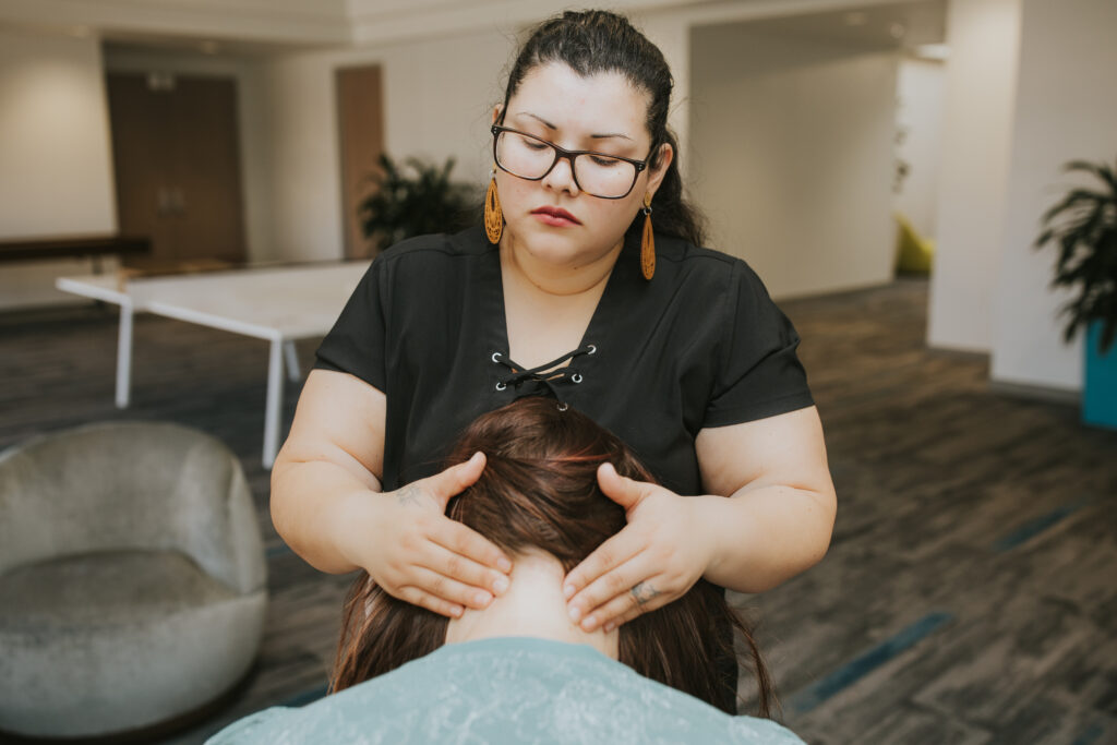 Employee receiving chair massage during a workplace wellness event as part of an employee wellness solution that reduces stress and boosts morale.