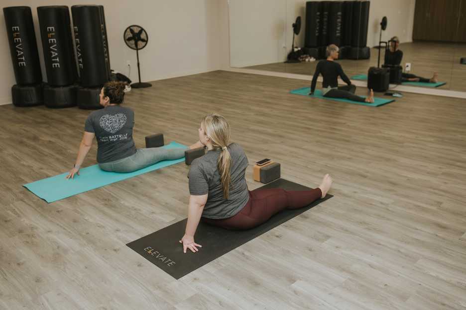 Employees practicing mindfulness with yoga stretching class for improved well-being at work and better sleep overall.