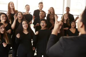 Workplace wellness: employees singing as part of a choir to boost mental health at work and wellbeing at work.